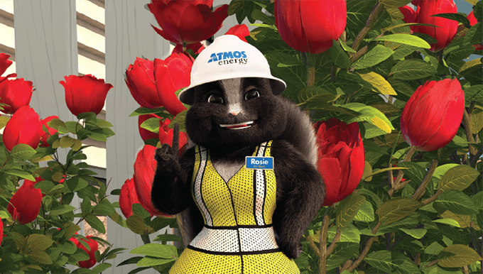 Rosie the Skunk with an Atmos' Energy hard hat on standing in front of flowers
