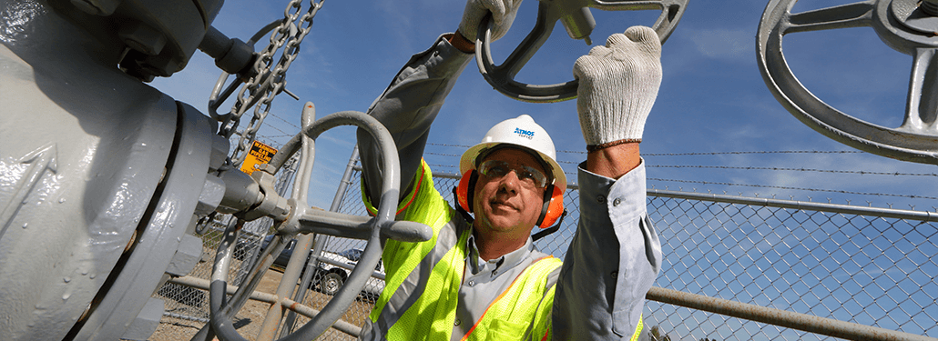 Atmos Energy employee turning natural gas valve