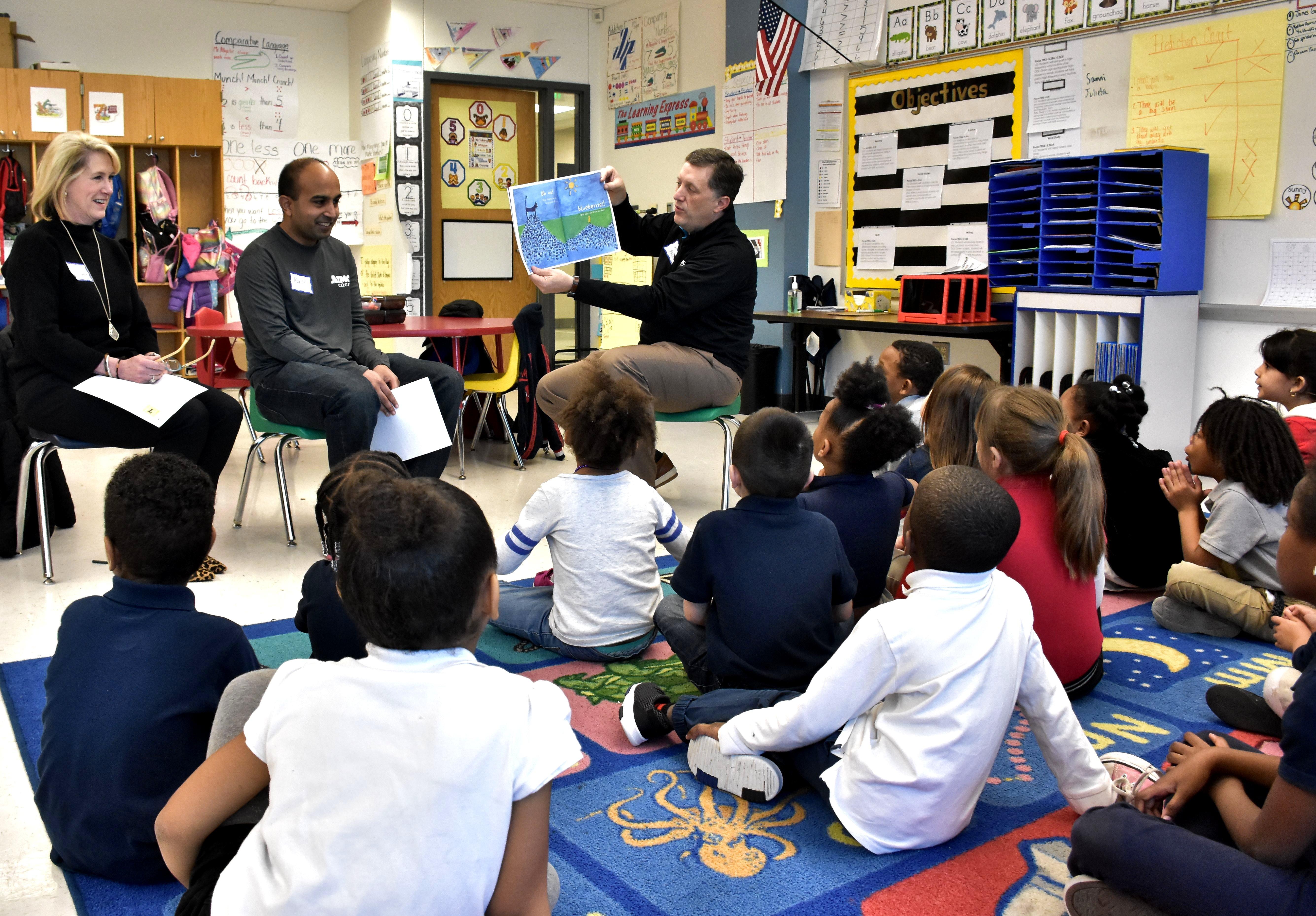 three adults teaching children in a classroom