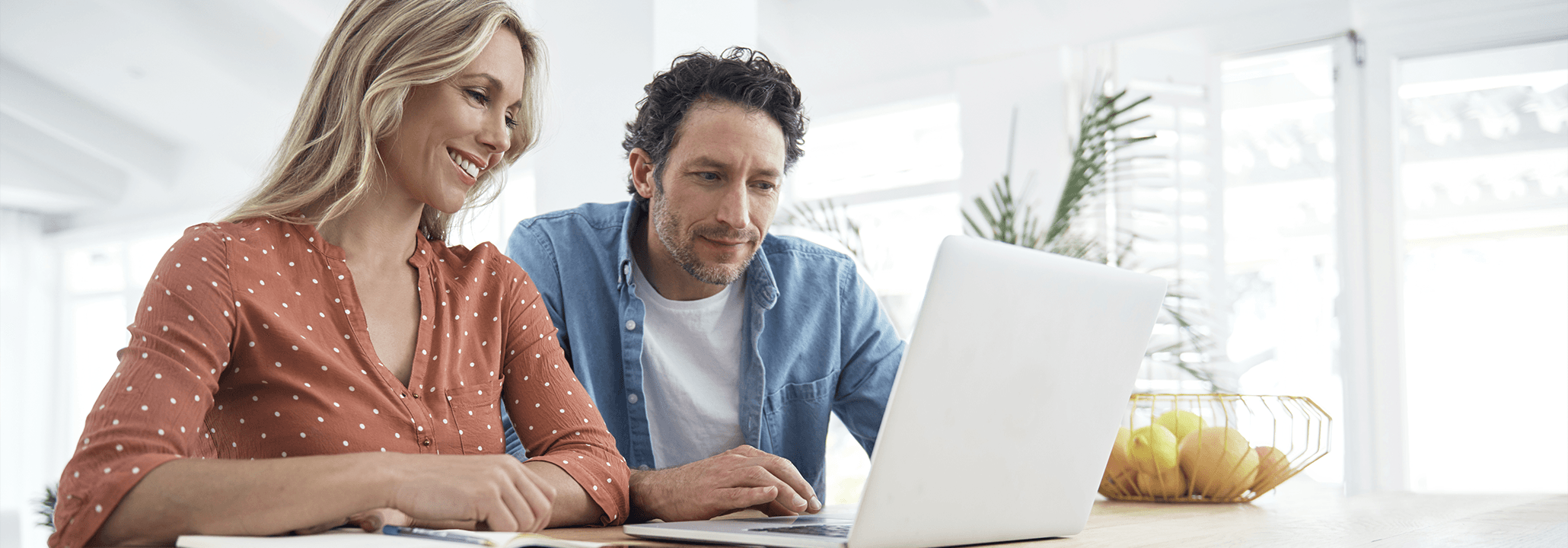 a woman using a laptop sitting next to a man