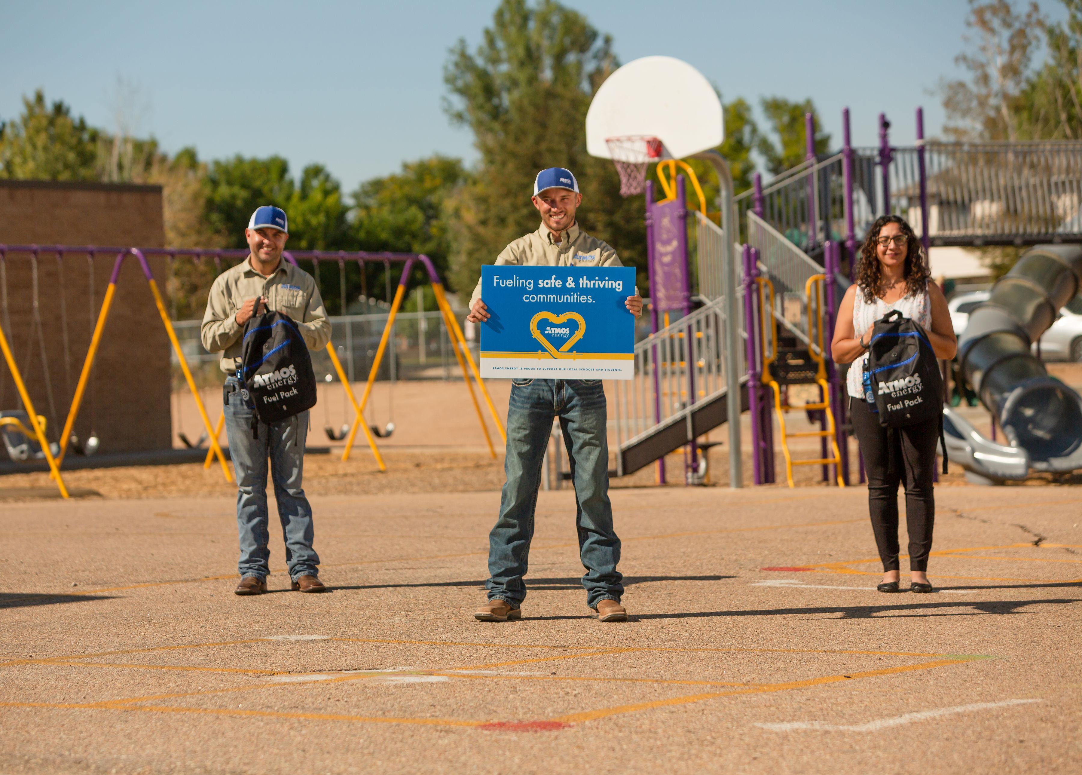 Atmos Energy employees deliver backpacks to local school